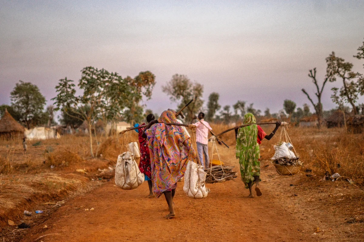 Villagers carrying loads at dusk