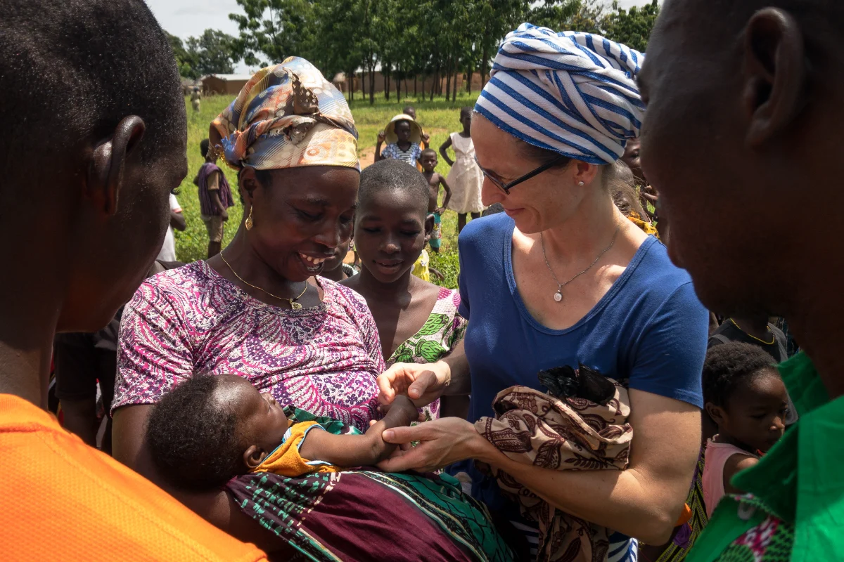 A missionary greeting a mother and child